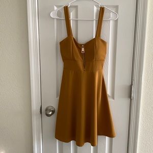 Mustard colored mini dress. With a front zipper.